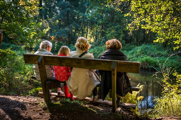 Familie zit op een bakje en geniet van de natuur in Roermond