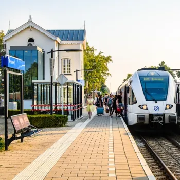 Reizigers stappen uit de trein op station Reuver, op de lijn richting Roermond, op een zonnige dag