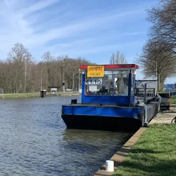 Dieselpomp aan het water bij een aanlegsteiger, met bord 'Open Diesel €1.15'.